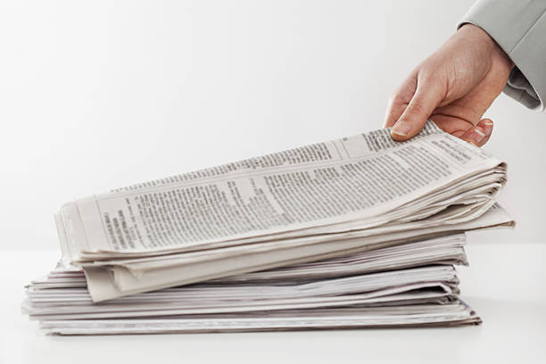 istock Woman hand holding newspapers on table 638224712