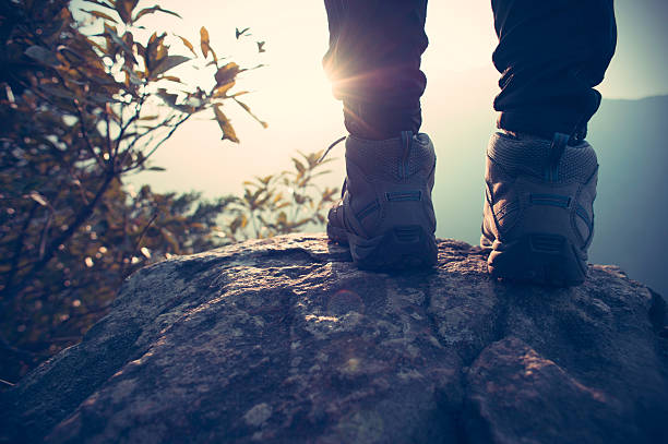 successful hiker legs on mountain peak rock