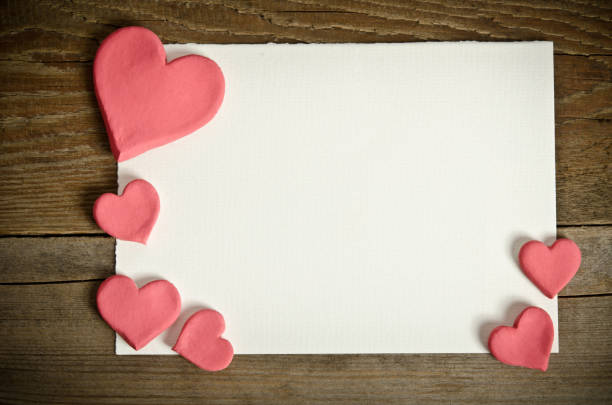 istock white paper with small pink hearts on a wooden background 638226816