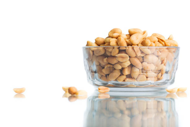 Peeled and salted peanuts in a bowl. Isolated on a white background