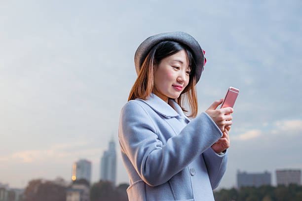 istock young woman in blue and hat holds cellphone 638228572