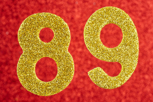 istock Number eighty-nine yellow color over a red background. Anniversa 638229362