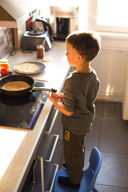 istock Boy  making and eating pancakes 638229522