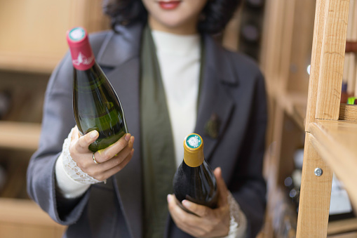 young asian woman holds red wine