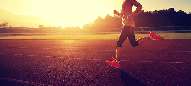경기장 트랙에서 화창한 아침에 달리는 젊은 여성 - shoe sports shoe profile sport 뉴스 사진 이미지