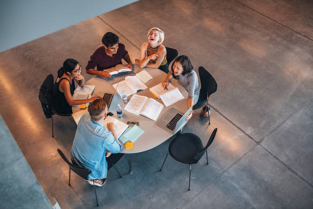 istock Group of students sitting together at table 638234938