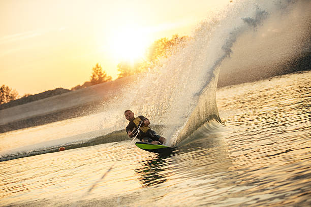 человек вейкбординг на озере - wakeboarding waterskiing water ski sunset стоковые фото и изображения