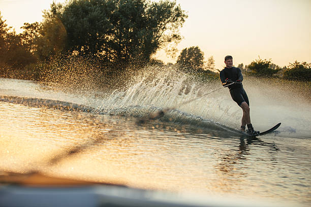 istock Man wakeboarding on lake behind motorboat 638236598