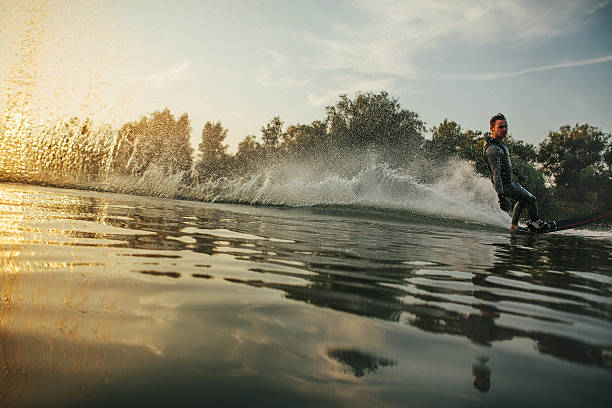istock Wakeboarder skiing on lake at sunset 638237304