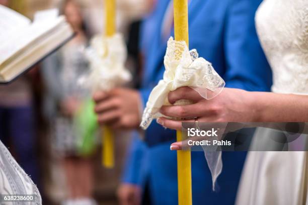 Bride And Groom Holds Candles Decorated Wtih White Flowers Stock Photo - Download Image Now