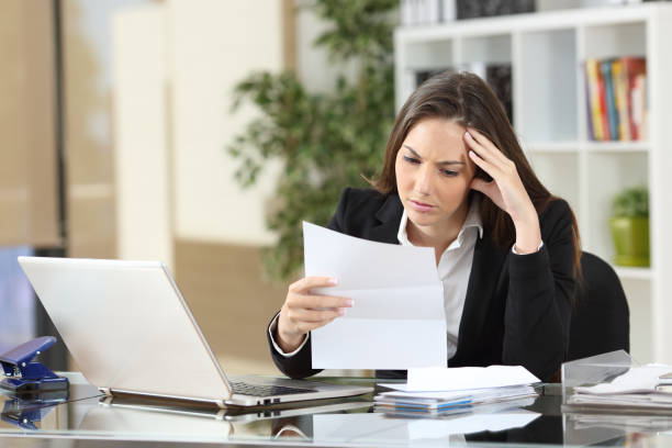 worried businesswoman reading a notification - finishing employment issues occupation downsizing imagens e fotografias de stock