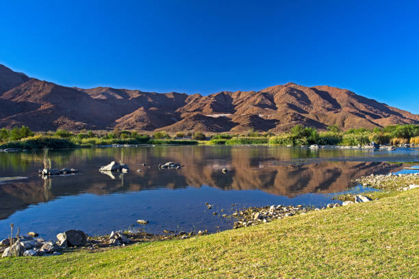 montañas del desierto a través del río lush orange - richtersveld national park fotografías e imágenes de stock