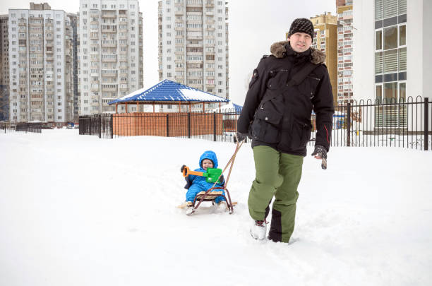 istock Young father and son sledding at winter time 638241626