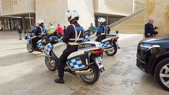 Valetta, Malta - December 13, 2016: safety escort for Malta president Marie Louise Coleiro Preca at national celebration day - december 13. in  2016. Police motorcycles driving with the limousines in convoy trough the city Valetta. In the streets some people and TV teams.  