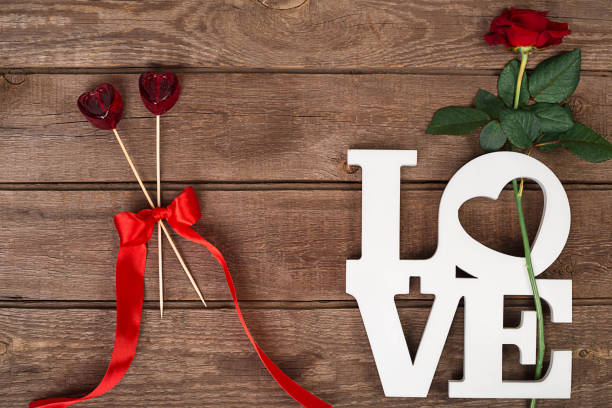 istock Red rose and candy over wooden background 638243182