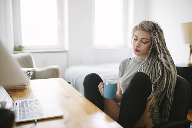 Woman Enjoying her Morning Coffee Young woman enjoying morning coffe behind the desk. gray hair young woman stock pictures, royalty-free photos & images