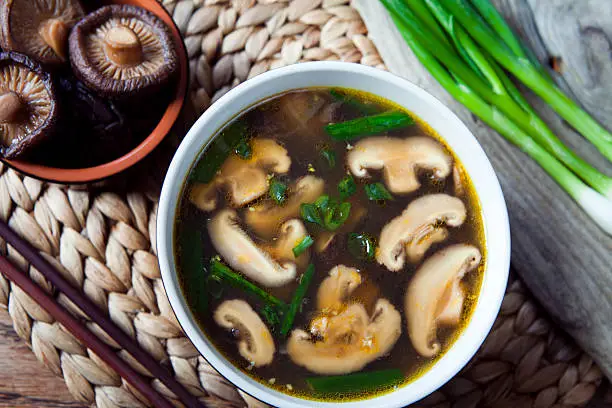 Shiitake mushrooms asian  soup -  clear delicious broth with spring onions.