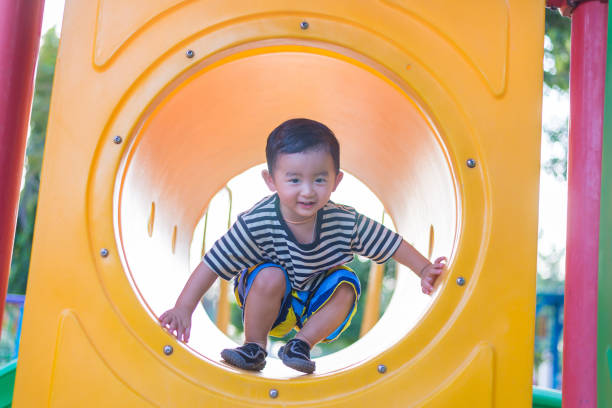 istock Cute Asian boy playing and smiling in yellow tunnel 638244470