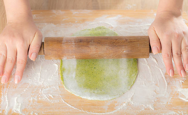 rollt den teig einen nudelholz - baking dough human hand rolling pin stock-fotos und bilder