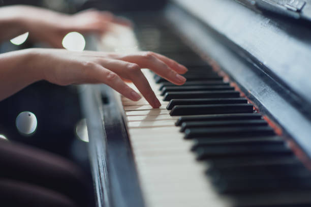 istock girl playing on an old piano. Beautiful blur background 638249110