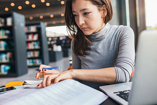 istock Young woman studying on a book and taking notes 638250660