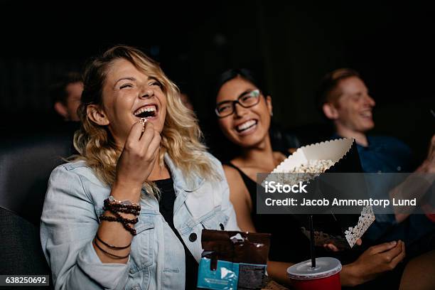 Young Woman With Friends Watching Movie Stock Photo - Download Image Now - Movie Theater, Movie, Popcorn