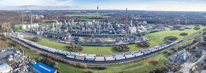 Moers, Germany - December 26, 2015: Train waiting in front of petrochemical plant, aerial