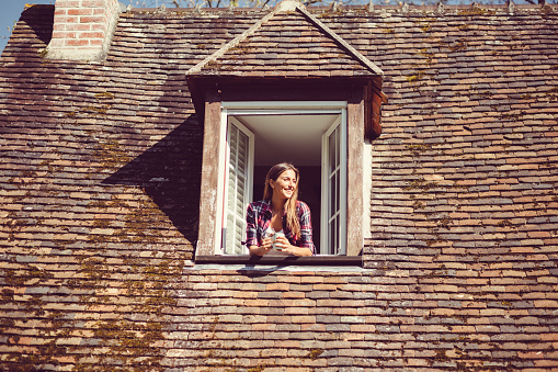 Happy woman with cup of tea on the rooftop window