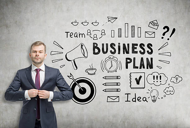 istock Businessman buttoning his suit near a business plan sketch 638257976