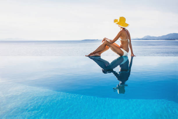 istock Young woman enjoying sun on infinity pool 638258528