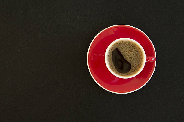 istock Red cup of coffee on black background top view 638261674