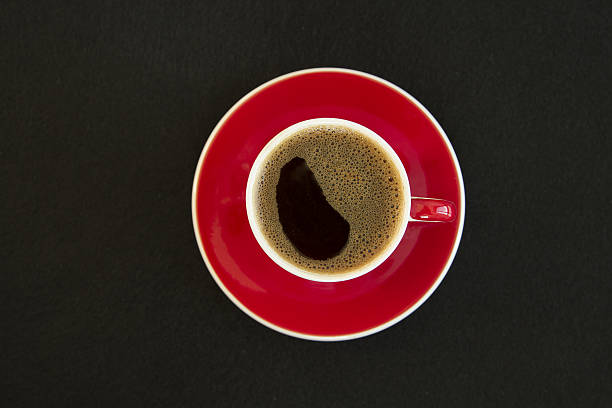 istock Red cup of coffee on black background top view 638261758