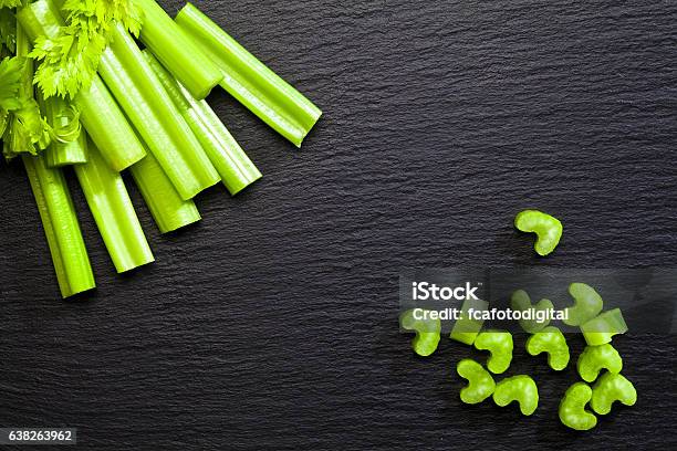 Sticks And Chopped Celery On Dark Background Stock Photo - Download Image Now - Celery, Directly Above, Celery Sticks