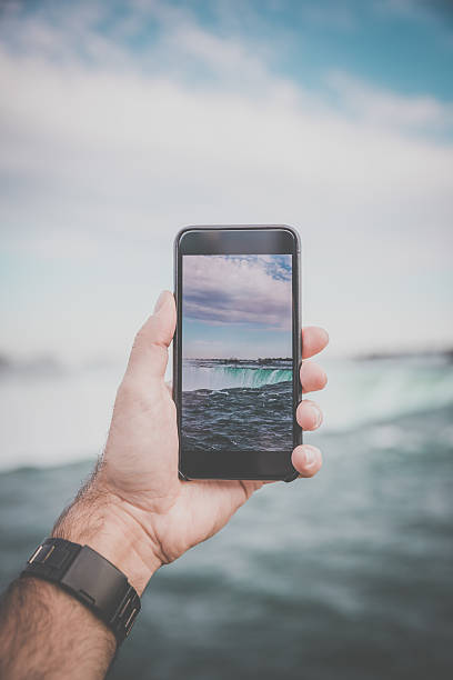 human hand taking picture w: niagara falls with smart phone - niagara falls falling people usa zdjęcia i obrazy z banku zdjęć