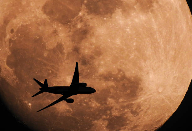 istock Silhouette airplane flying across the moon 638266968