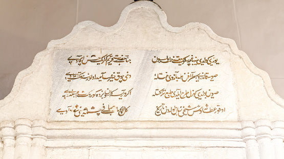 Upper inscription in Arabic script, the Fountain of Tears. The most famous monument of Khan's Palace (1764). Fountain authorship is attributed to Master Omer. Upper fountain inscription - the poem the poet Sheikhyi, glorifying Khan Giray. Bakhchisaray Palace. Crimea, Russia. Panorama of three frames, daylight.
