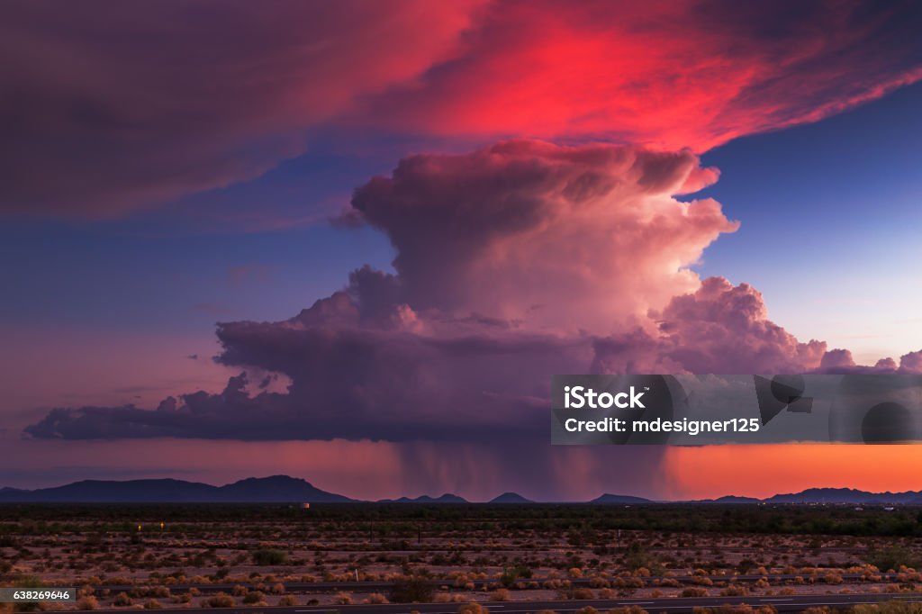 Sunset storm clouds Sunset storm clouds reflect colorful light as a thunderstorm builds on the horizon. Monsoon Stock Photo