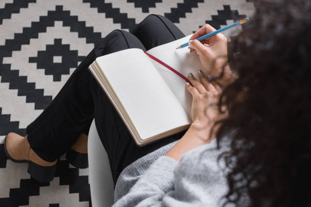 istock Overhead view of woman writing in notebook 638275648