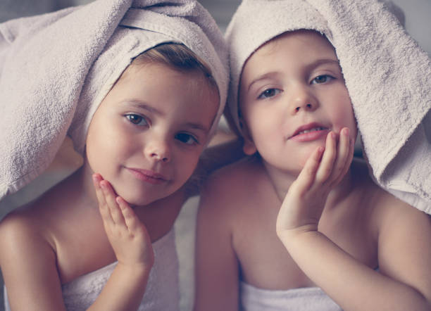 Morning routine. Two cute little girls with towels on the head posing to the camera. Beauty staffs. girls bath stock pictures, royalty-free photos & images