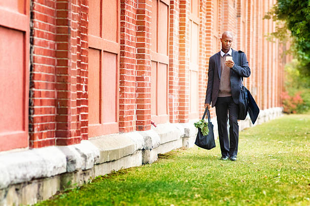 istock Single professional black man walking home with groceries 638285572