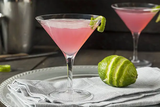 Homemade Pink Vodka Cosmopolitan Drink with a Lime Garnish