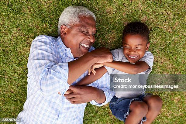 祖父と孫は草の上に横たわって遊ぶ空中写真 - シニア世代のストックフォトや画像を多数ご用意 - シニア世代, 子供, 祖父