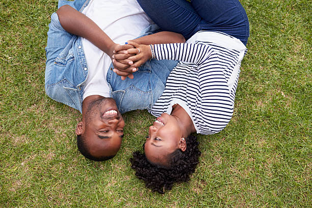 istock Young black couple lying on grass look at each other 638287662