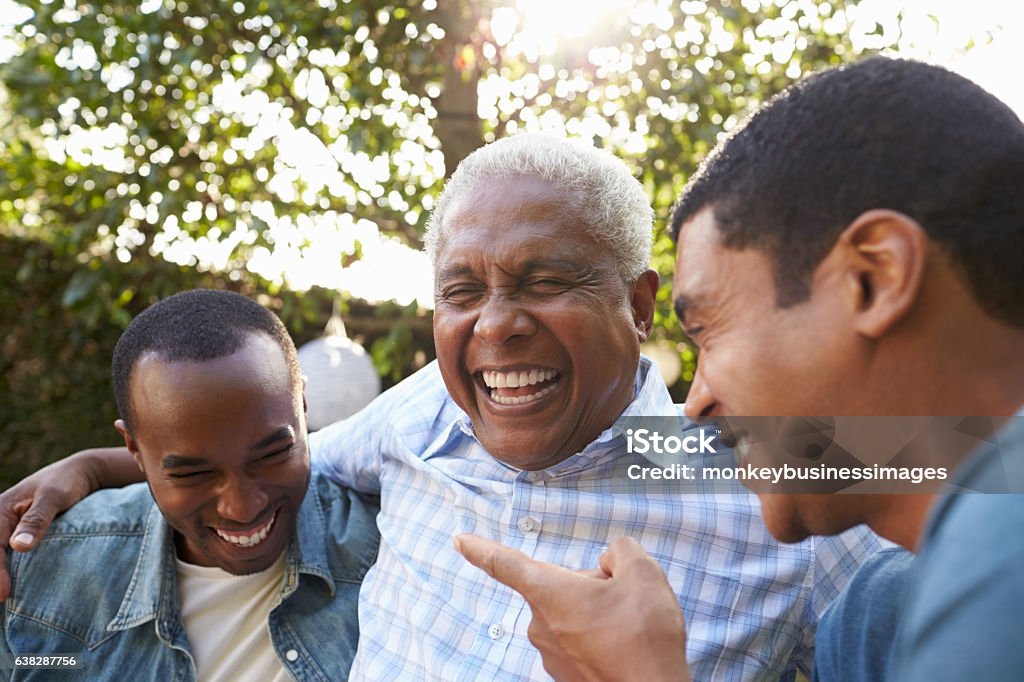 Hombre mayor hablando con sus hijos adultos en el jardín, - Foto de stock de Tercera edad libre de derechos