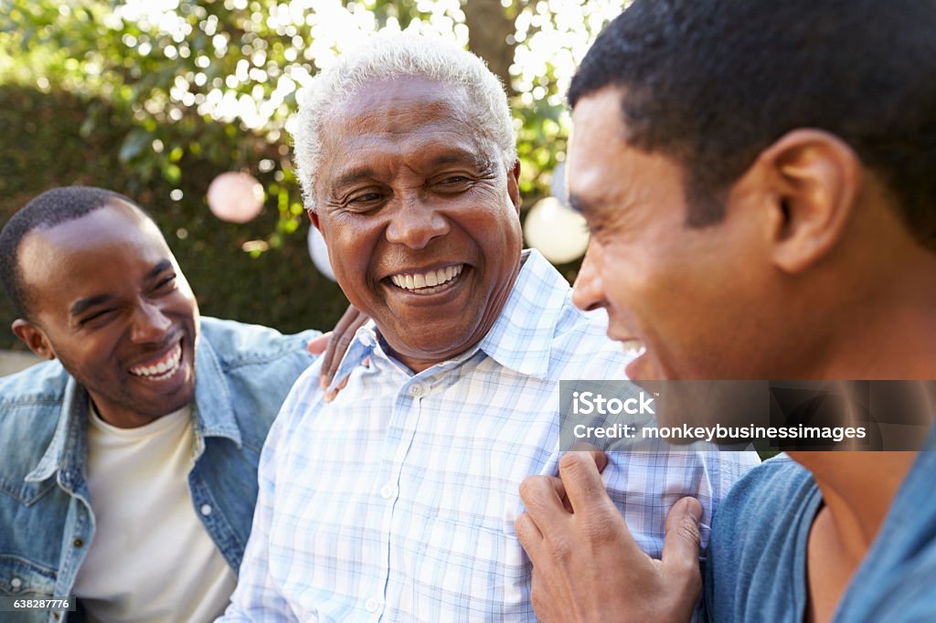 Senior man talking with his adult sons in garden, Senior man talking with his adult sons in garden, close up Senior Adult Stock Photo