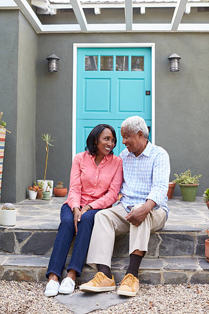 istock Senior couple sit on steps outside their house, vertical 638287868