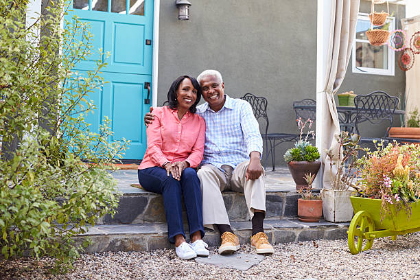 istock Senior couple sit on steps outside their house, full length 638287940