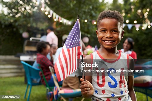 istock Young black boy holding flag at 4th July family garden 638288282