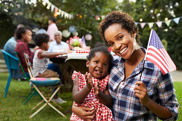 black mother and baby hold flag at 4th july party, - babies and children close up horizontal looking at camera imagens e fotografias de stock