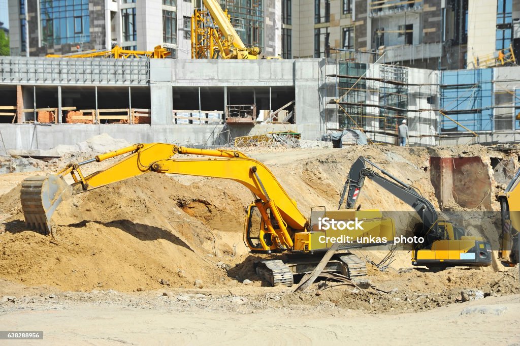 Excavating machine on construction site Work of excavating machine on building construction site Digging Stock Photo